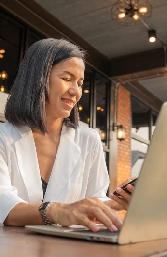 donna che lavora al pc in uno spazio comune come la sala, la hall o il dehor di un hotel italiano donna che lavora al pc in uno spazio comune come la sala, la hall o il dehor di un hotel italiano